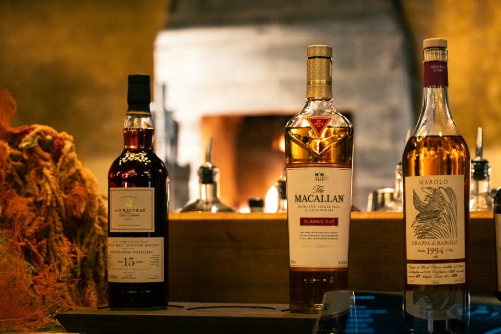 Bottiglie rare da collezione con Macallan in primo piano, ambientazione da cantina